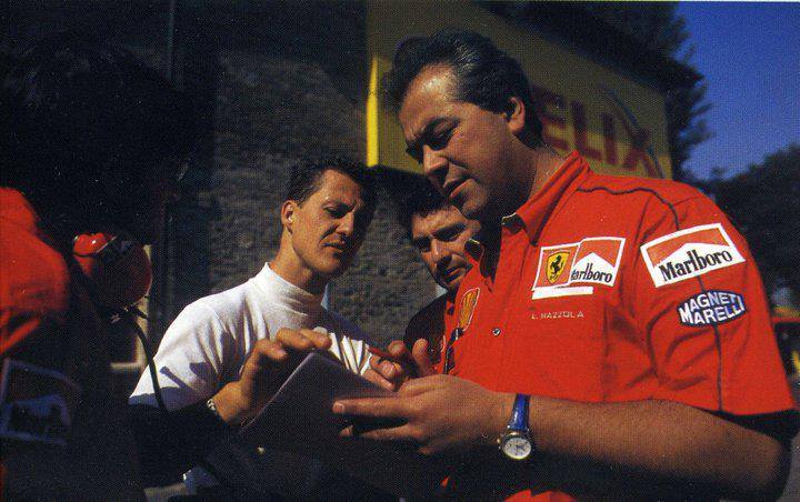 Luigi Mazzola e Michael Schumacher ai box Ferrari, con un foglio di appunti